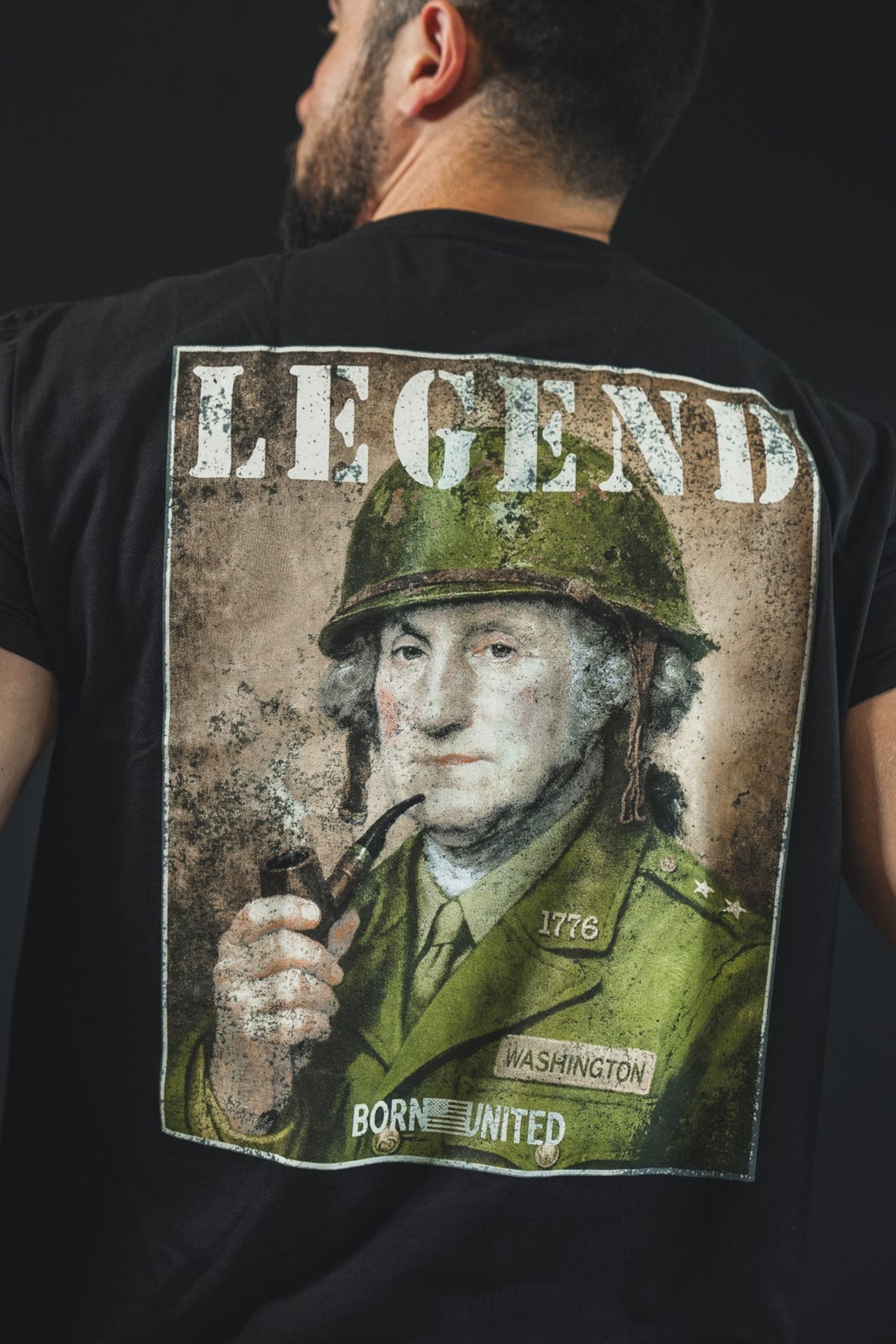 A tattooed man wears the "Legend - Washington" tee by Born United Private Label, showing George Washington in military dress with LEGEND above and BORN UNITED below—ideal for history buffs and lovers of American heritage.