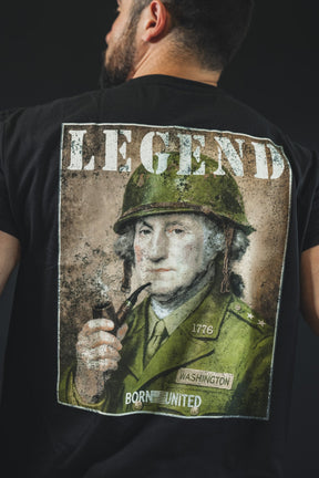 A tattooed man wears the "Legend - Washington" tee by Born United Private Label, showing George Washington in military dress with LEGEND above and BORN UNITED below—ideal for history buffs and lovers of American heritage.