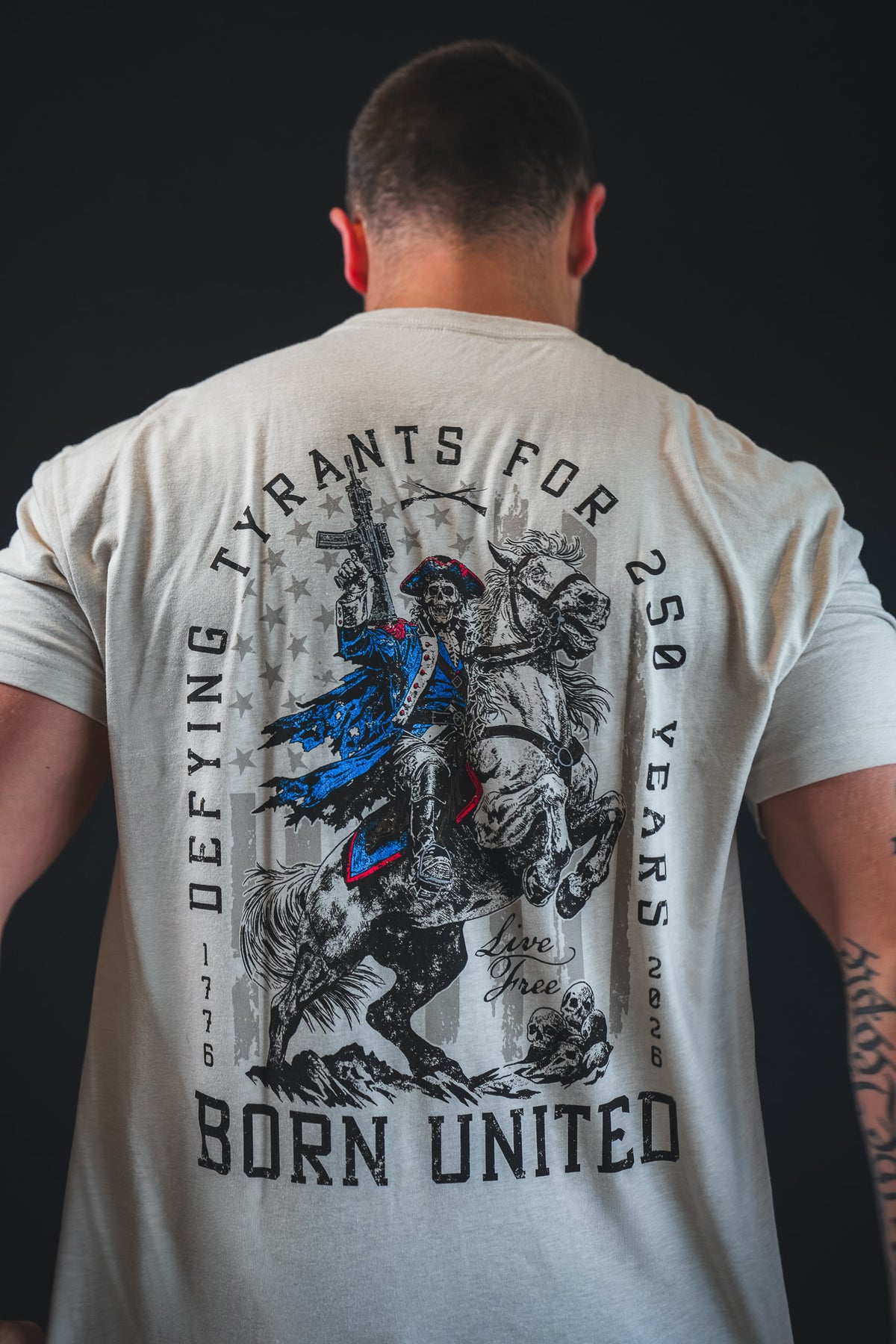 Wearing the Born United Private Label 250th Anniversary Tee, featuring a Revolutionary War soldier and "Defying tyrants for 250 years, 1776-2026." Celebrate American resilience with this special edition!.