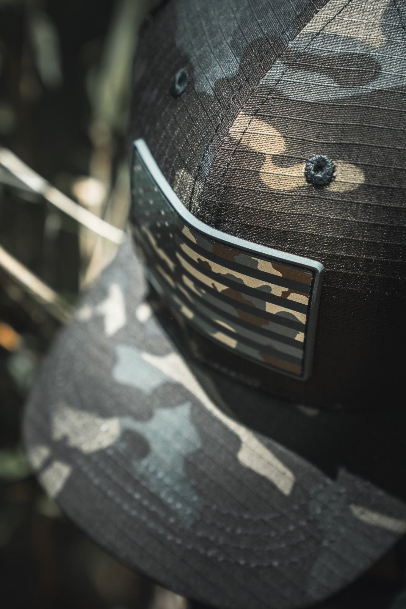 Camouflage baseball cap with a logo on a blurred natural background
