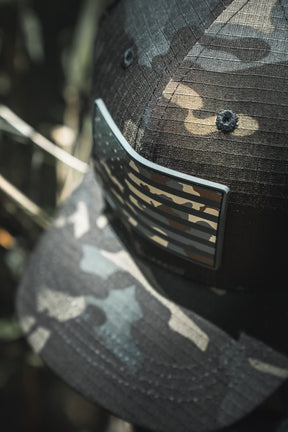 Camouflage baseball cap with a logo on a blurred natural background