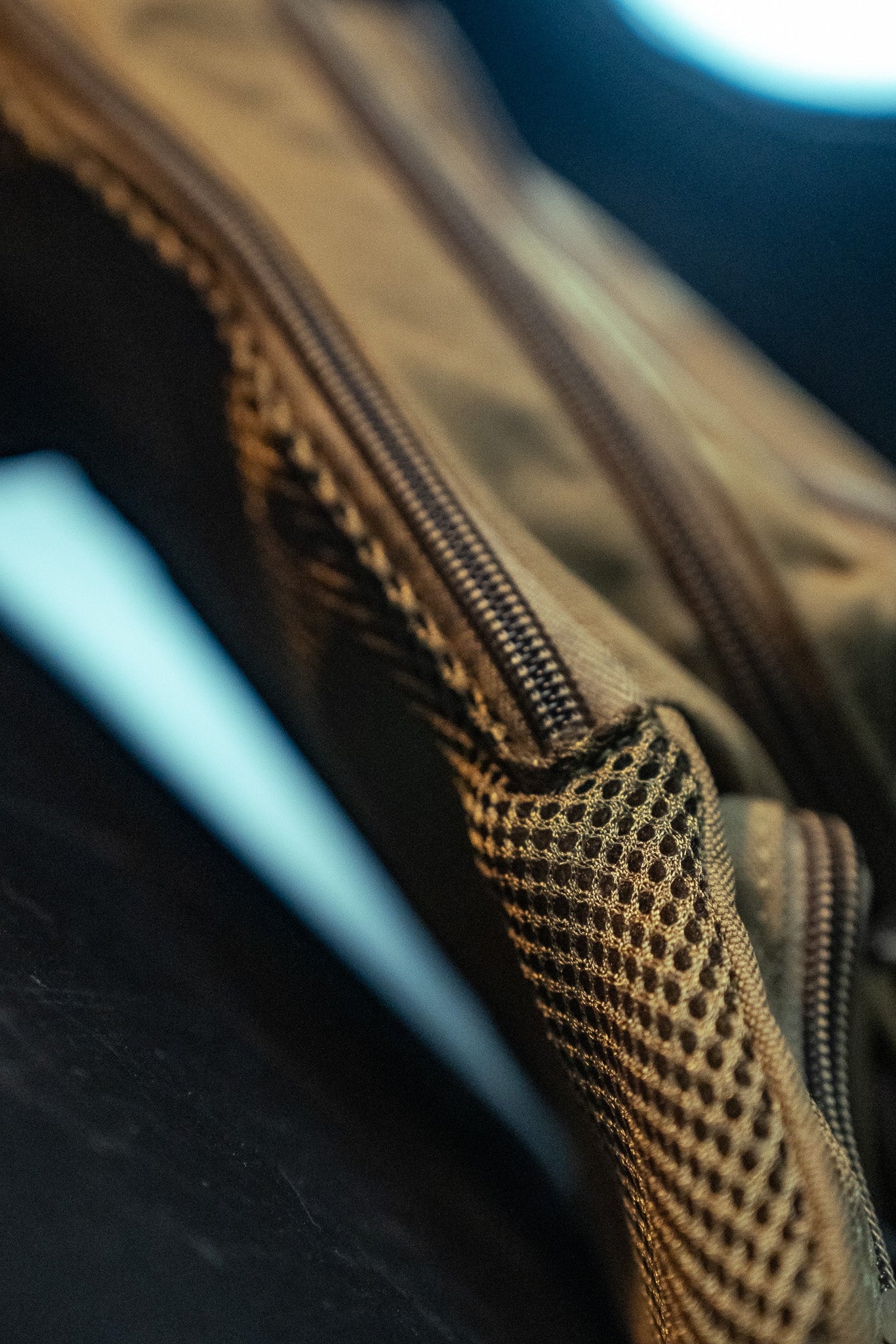 Close-up of the Coyote Tac-Fanny-Pac by Born United Private Label showcases its brown tactical fabric and visible zipper, with soft lighting emphasizing texture, stitching, and material. A blurred background directs attention to its craftsmanship.