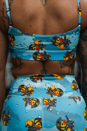 A person sports BORN UNITED's Women's High-Waisted Seamless Front Compression Training Shorts | Tacti-Quack, featuring cartoon duck and scuba diver prints. Visible tattoos on their back and arm highlight the bold design.