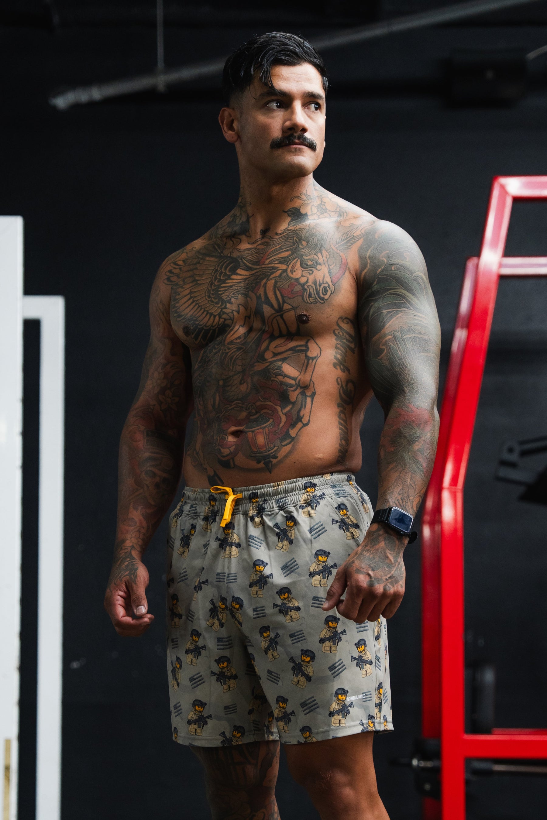 Man with tattoos standing in a gym setting
