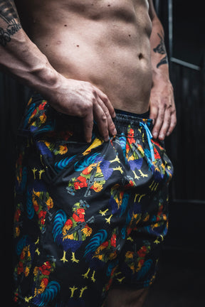 Person wearing colorful patterned shorts with a dark background