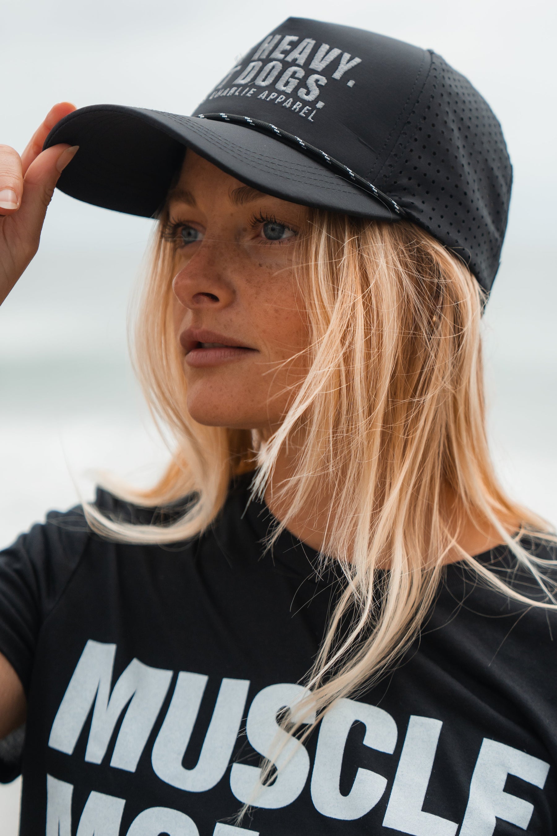 Person wearing a black cap and t-shirt with visible branding against a neutral background