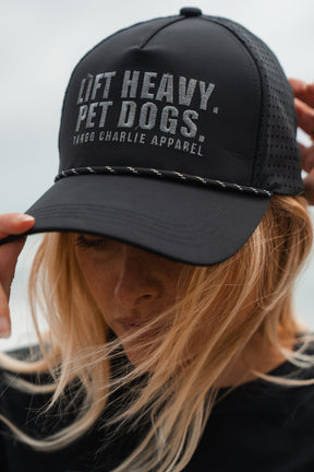 Person wearing a black cap with 'Lift Heavy Pet Dogs' text, blurred background