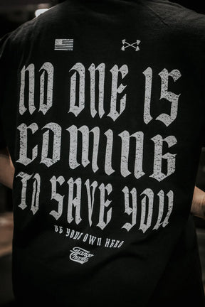The No One Is Coming To Save You Tee - Black by Tango Charlie Apparel features bold white gothic lettering with the quote: NO ONE IS COMING TO SAVE YOU. BE YOUR OWN HERO, plus flag and arrow graphics for standout inspiration.