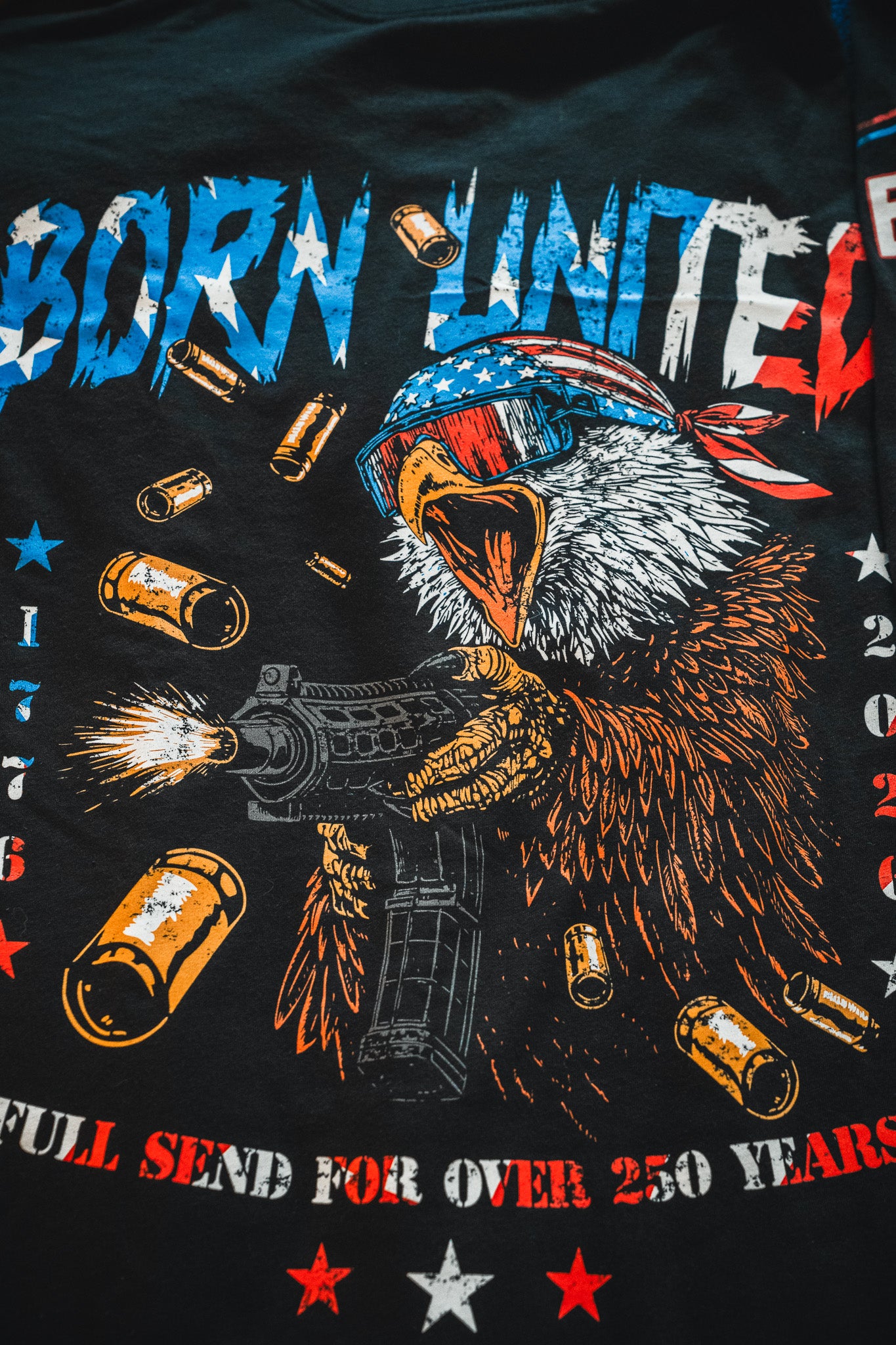 A bold graphic of a bald eagle in a flag bandana and sunglasses fires a machine gun beneath "BORN UNITED"—patriotic stars and colors mark the Born United Patriot Box by Born United Private Label, perfect for America’s 250th birthday celebration.