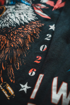 Close-up of a dark fabric from the Born United Patriot Box by Born United Private Label, featuring a graphic with an eagle, stars, and "2026" in red and white. This Limited Edition Tee honors America's 250th Birthday with bold patriotic flair.