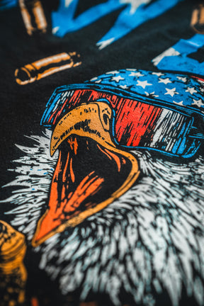 Close-up of a bald eagle with its beak open, wearing American flag sunglasses and surrounded by bullet illustrations on a dark background. Perfect for the Born United Patriot Box by Born United Private Label—celebrating America's 250th Birthday!.