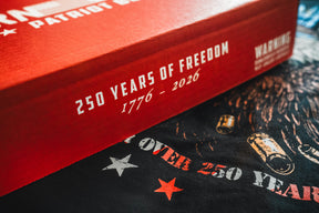 Red box with white text reading 250 Years of Freedom 1776–2026 and a partial Warning; the Born United Patriot Box from Born United Private Label rests on a dark surface with bullet and star images, celebrating America's 250th Birthday.