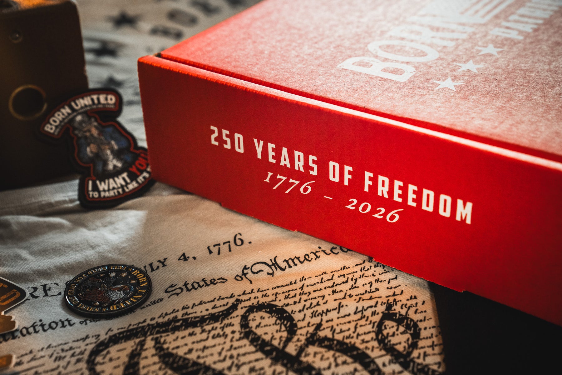 The Born United Patriot Box by Born United Private Label features “250 Years of Freedom 1776 - 2026” with patriotic items like a U.S. Constitution replica, a coin, and stickers—perfect for celebrating America’s 250th Birthday.