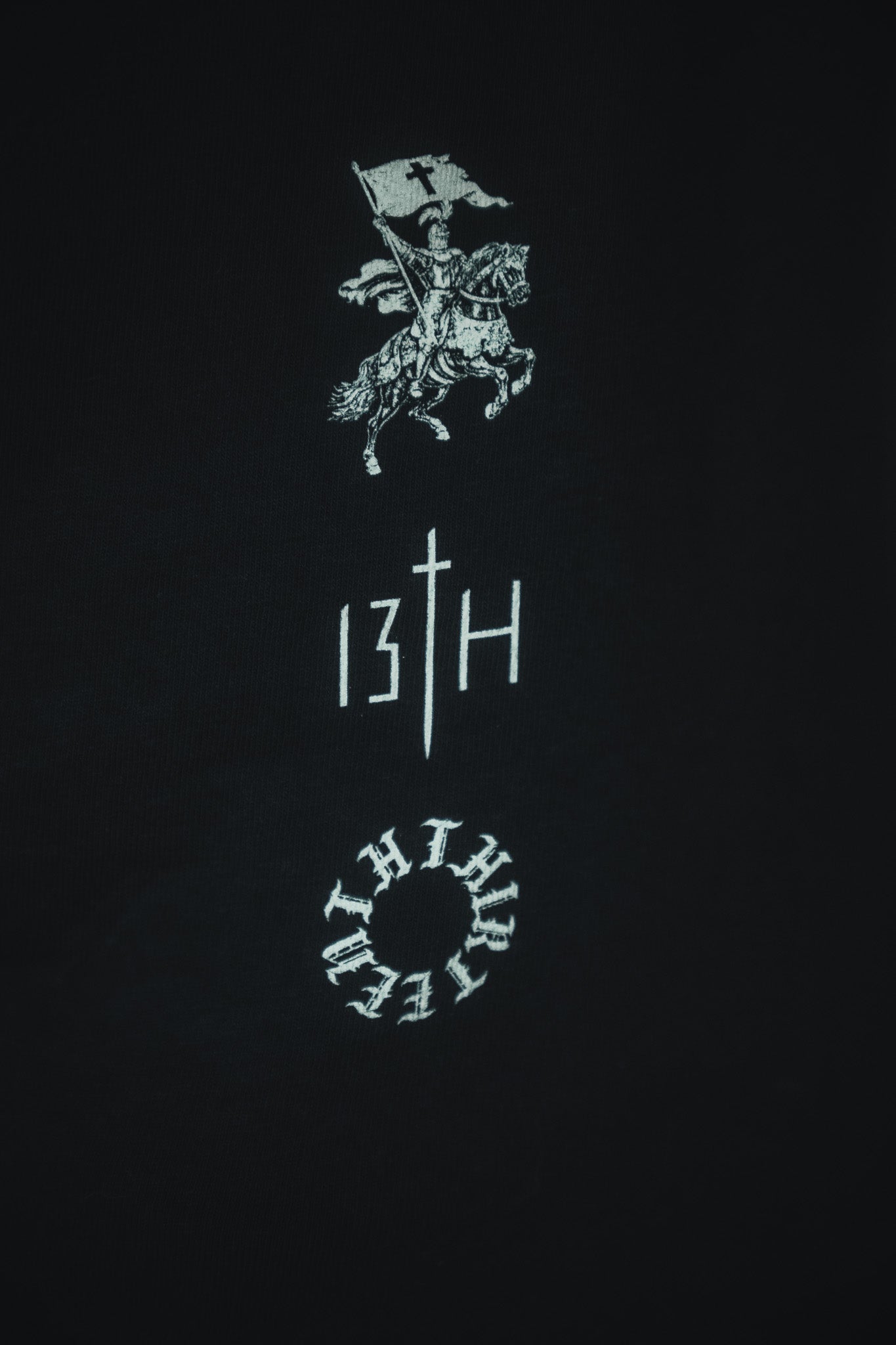 The Kingdom Over Everything Premium Tee by 13th features a bold white graphic of a knight on horseback with a flag, sword-inspired "T" in the logo, and circular design—reflecting the pursuit of God's kingdom above all.
