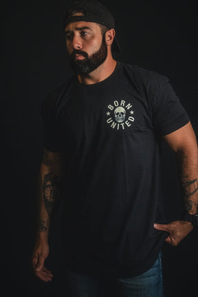 A bearded man wearing a black “Freedom of Speech” t-shirt from Born United Private Label and a backwards cap stands against a dark background, embodying the spirit of free expression.