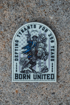 A 3" x 3" Velcro tear away 250th Anniversary PVC Patch by Born United Private Label is displayed on concrete, featuring a rider and the text: DEFYING TYRANTS FOR 250 YEARS, 1776-2026, LIVE FREE, BORN UNITED.