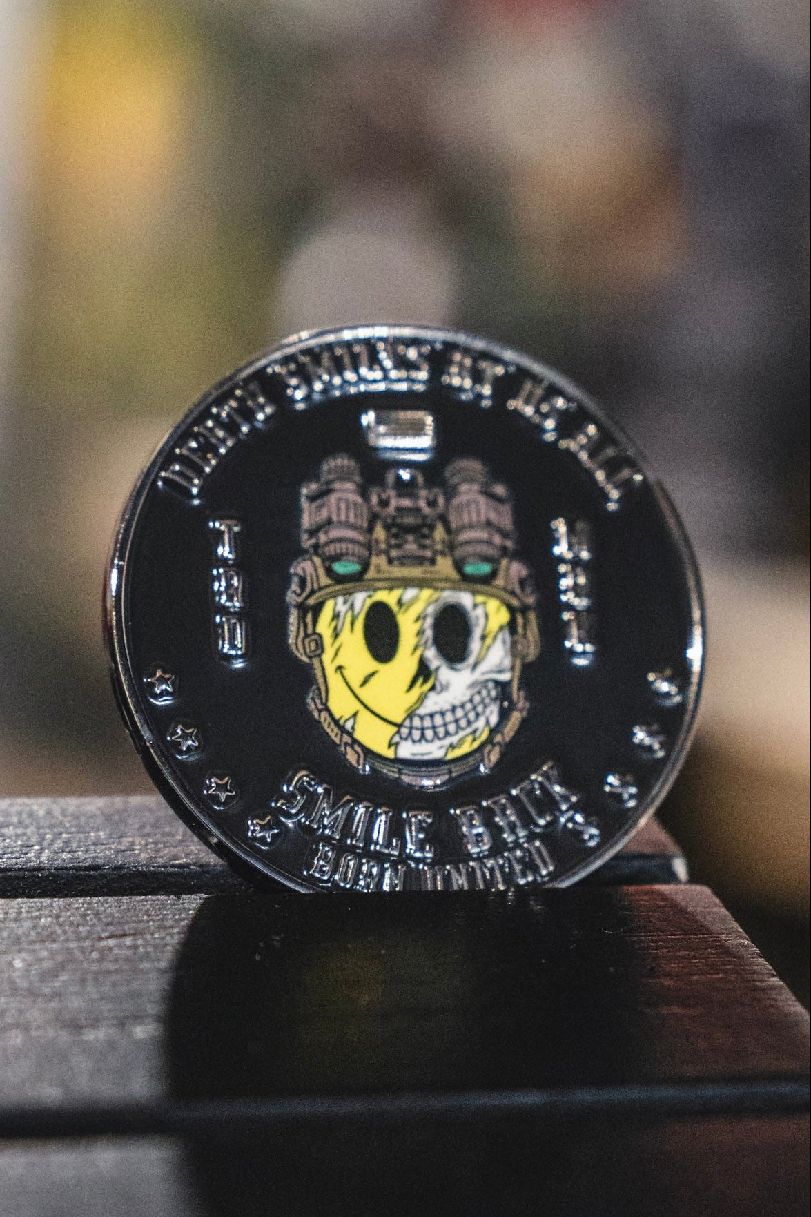 The Smile Back Challenge Coin from Born United Private Label is a round metal piece featuring a half-yellow, half-white skull with gears and the phrase “SMILE STICK BORN LIMITED” around the edge, making it a distinctive collectible that invites you to smile back at its fascinating design.