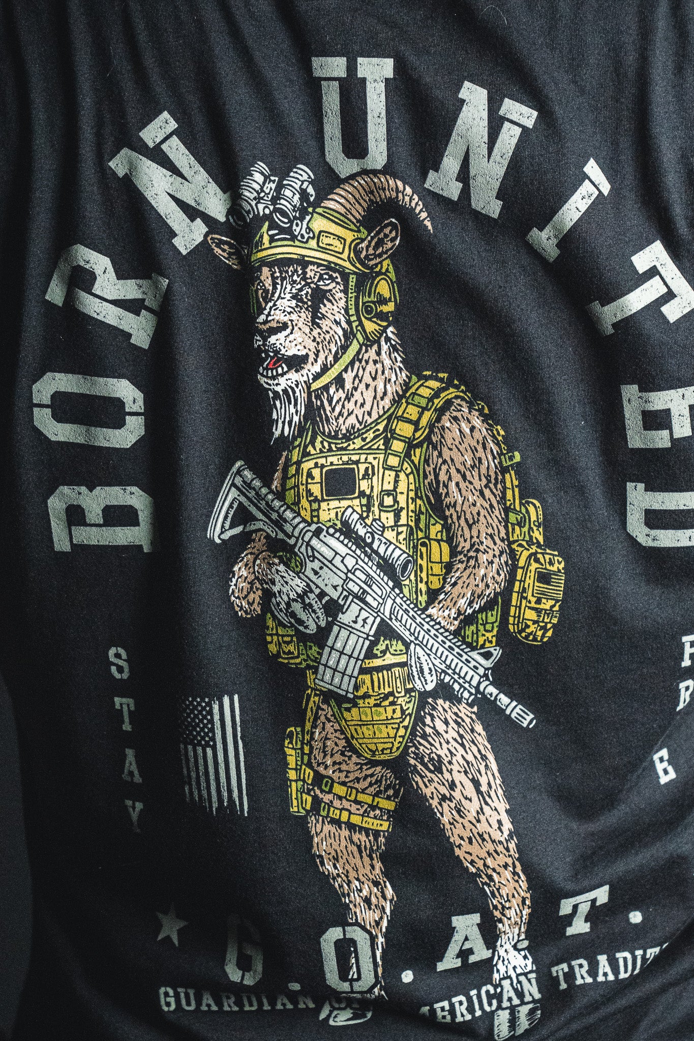 Show off your patriotic spirit with the Born United Private Label G.O.A.T. statement tee—featuring a bold graphic of a goat in tactical gear holding a rifle, alongside the text “BORN UNITED G.O.A.T. Guardian of American Tradition” and an American flag on classic black.