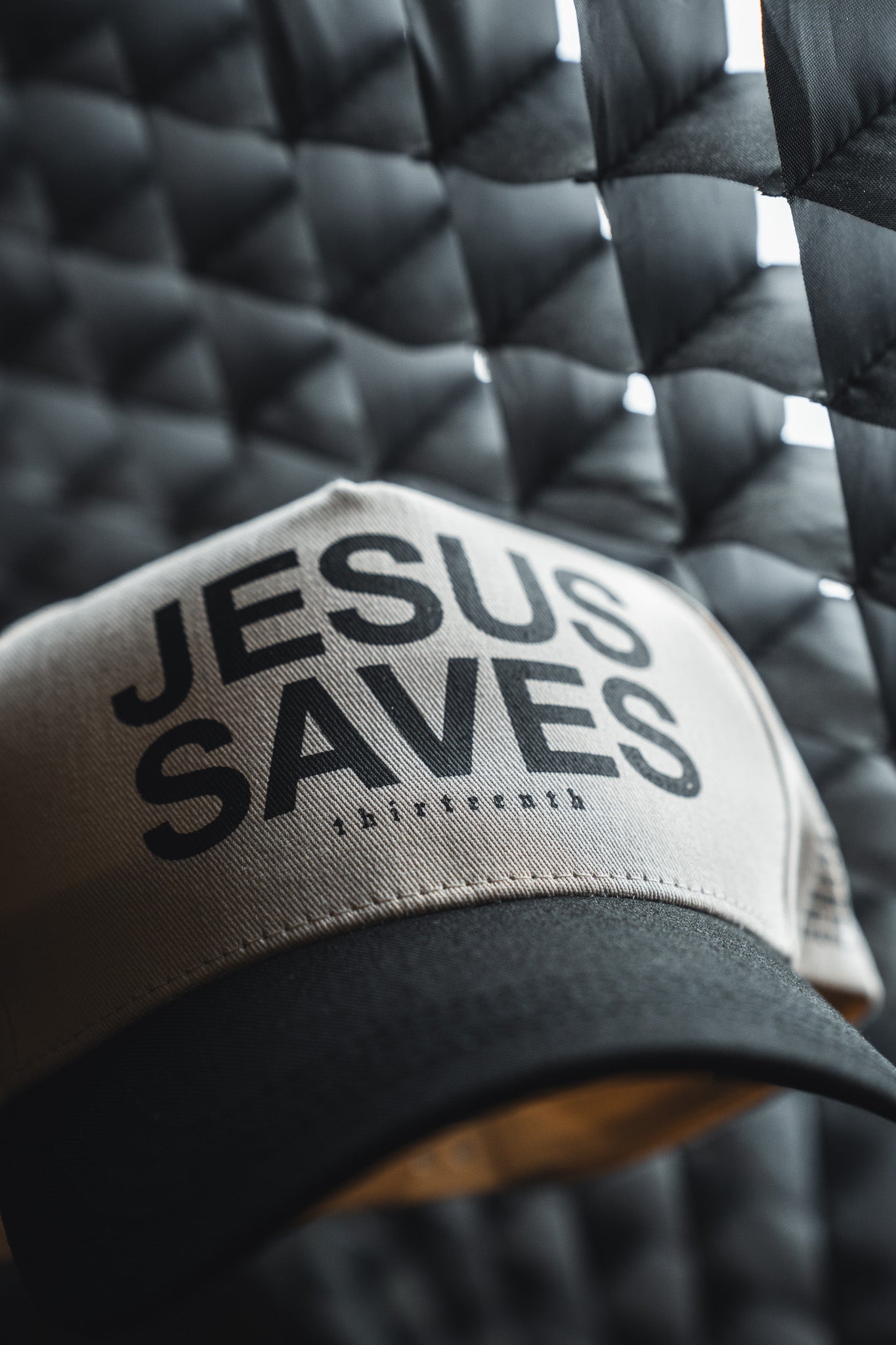 Showcase your faith in style with the 13th Jesus Saves Ivory and Black Snapback. This embroidered baseball cap features bold JESUS SAVES lettering on the front and comes in an eye-catching ivory and black colorway. Set against a quilted, patterned backdrop, this snapback hat makes a statement while providing a comfortable, adjustable fit.