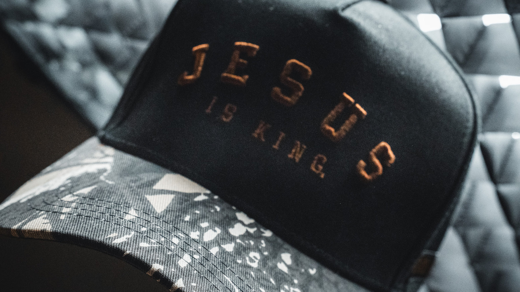 Introducing the Jesus is King - Black and Darkwood Camo Snapback from Born United Private Label—a stylish black and gray camo baseball cap featuring “JESUS IS KING” embroidered in bold brown letters on the front. This meaningful Christian hat is perfect for any occasion.