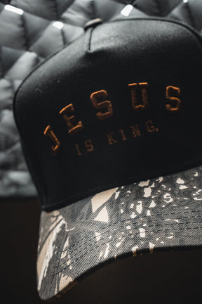 Introducing the Born United Private Label “Jesus is King - Black and Darkwood Camo Snapback,” a Christian hat featuring bold embroidery of the words JESUS IS KING on the front. This snapback combines sleek black fabric with a distinctive darkwood camo pattern, delivering both standout style and an inspiring message.