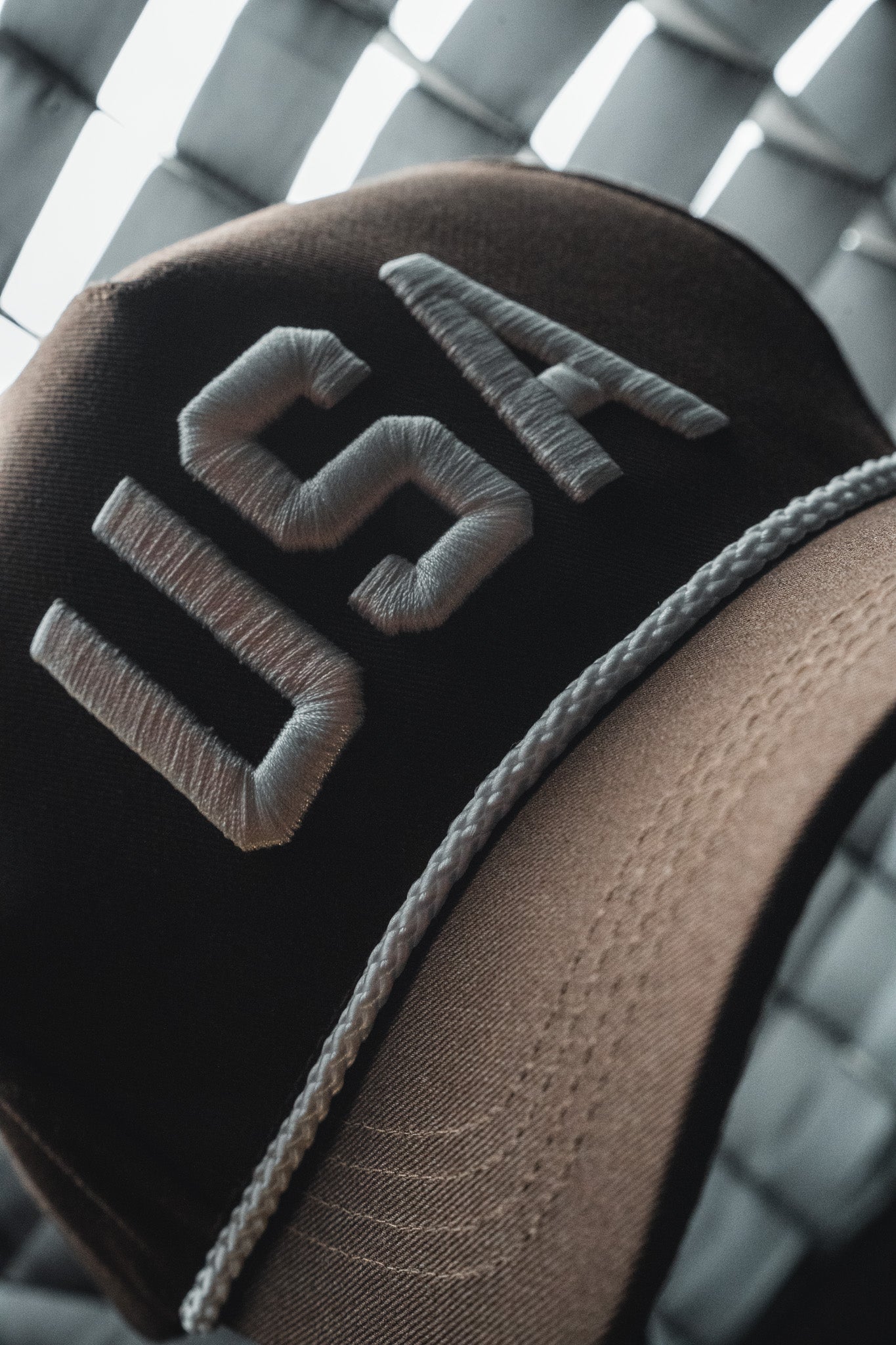 A close-up of the USA Brown Snapback Hat by Born United Private Label, featuring “USA” embroidered in white on the front.