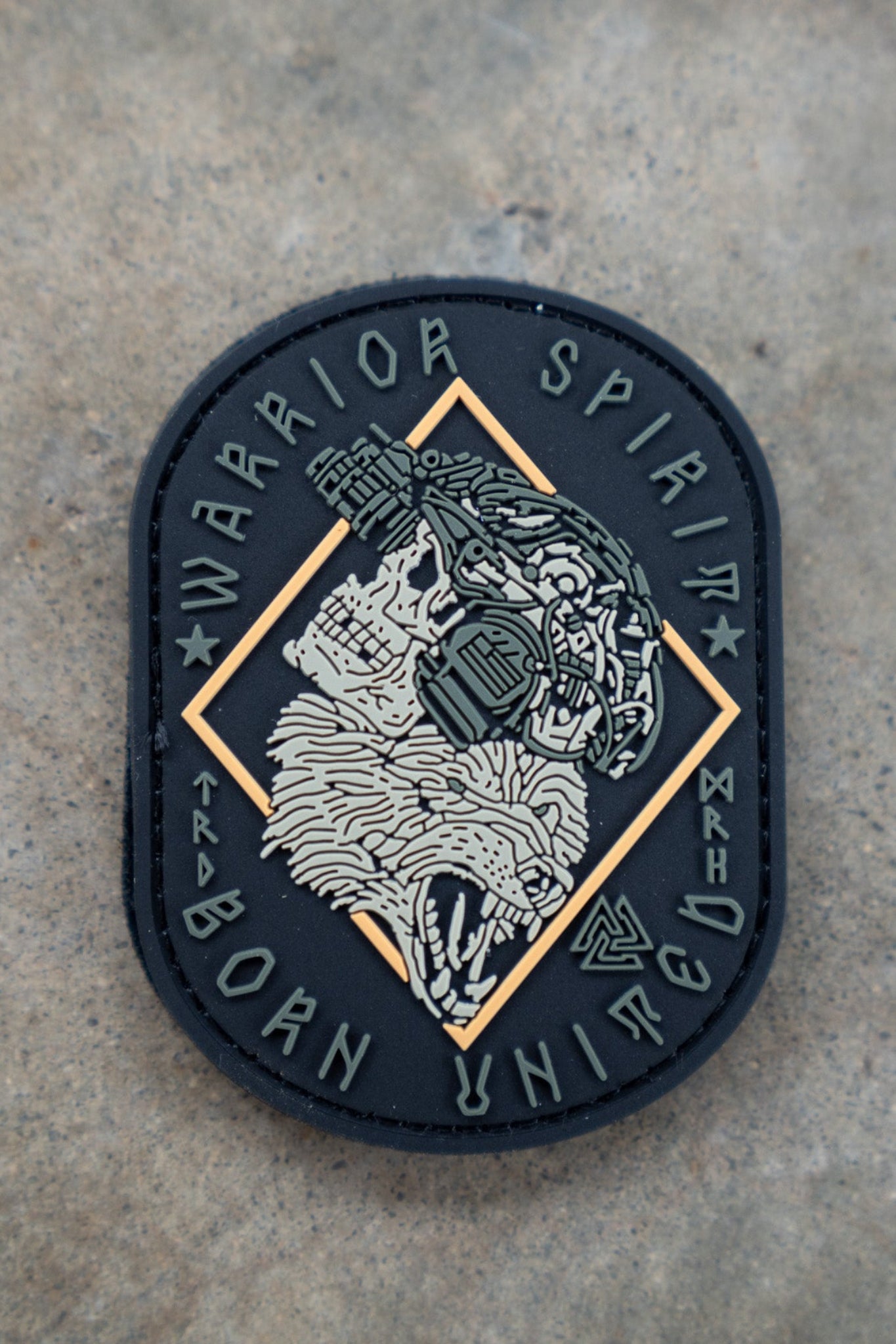 The Warrior Spirit PVC Patch by Born United Private Label features a roaring bear’s head with cyborg details, framed by “WARRIOR SPIRIT” on top and “BORN UNITED” below, set against a textured background.