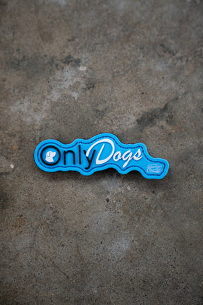 The Only Dogs PVC Patch by Tango Charlie Apparel features playful white and blue lettering with a small dog icon on blue, perfect for adding to concrete surfaces.
