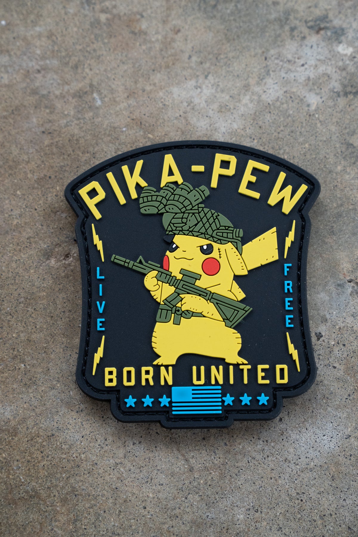 The Pika Pew PVC Patch by Born United Private Label features Pikachu with a rifle and tactical helmet, plus "PIKA-PEW," "LIVE FREE," and "BORN UNITED" text—perfect for fans with a Gotta Catch 'em All spirit.