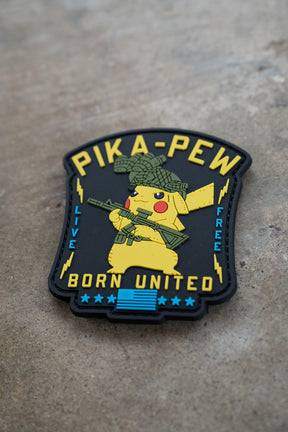 The Pika Pew PVC Patch by Born United Private Label shows Pikachu with a helmet and rifle, plus "PIKA-PEW," "LIVE FREE," and "BORN UNITED" in yellow and blue on black—ideal for Pokemon fans!.