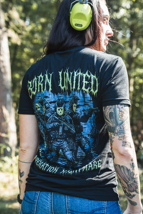 A person wearing a black Born United Private Label Operation Nightmare Tee - Glow in the Dark, featuring an exclusive graphic of soldiers in skull masks on the back.