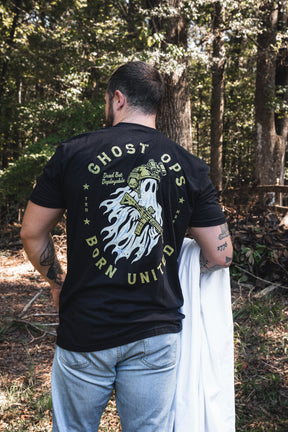 A person seen from the back wearing a black Ghost Ops Tee, featuring a graphic of a ghost in tactical gear holding a rifle with the text Dead But Deployable.