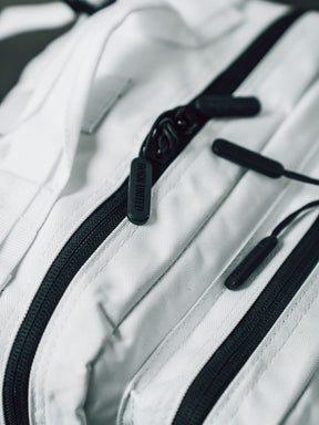 Close-up of the Born United Private Label Storm Trooper Tac-Pac - 45L, a white fabric bag with black zippers and pulls inspired by Stormtrooper armor, showcasing the detailed texture and quality hardware.