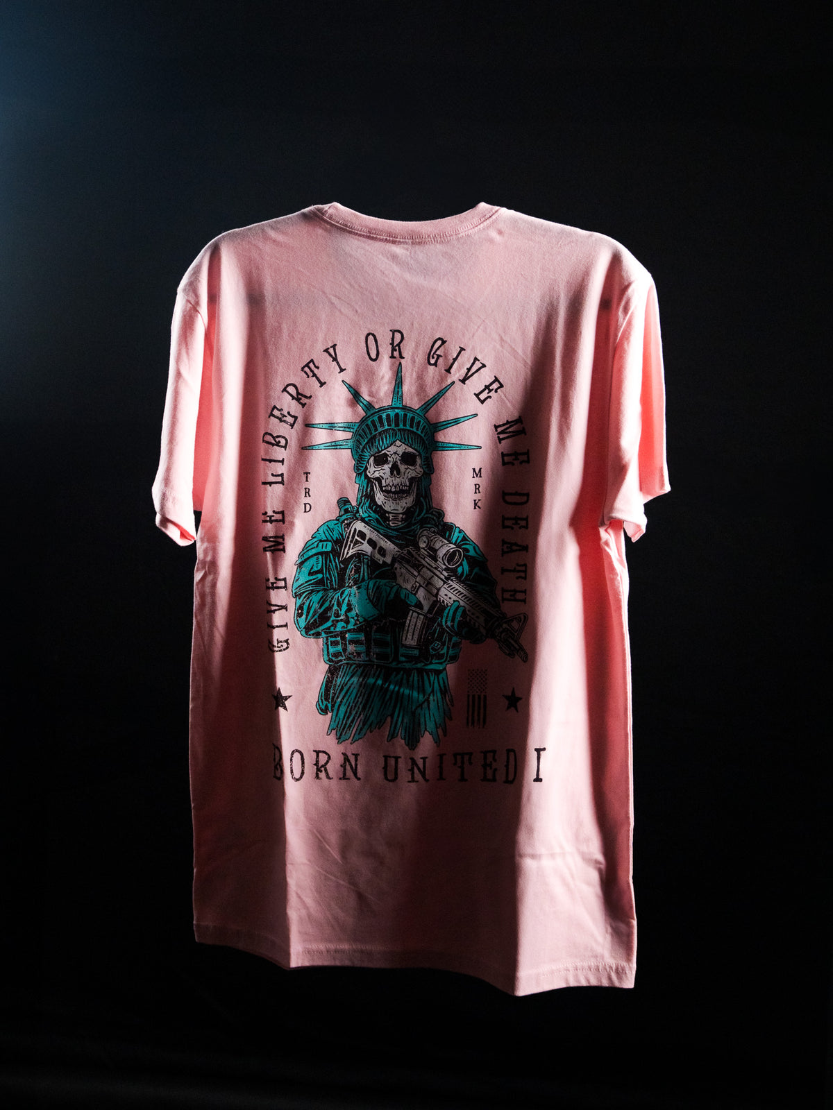 The Liberty Or Death- Heather Pink t-shirt by Born United Private Label features a skeletal Statue of Liberty with rifle and bold “Give Liberty Or Give Me Death” text—a striking, patriotic statement piece against a dark background.
