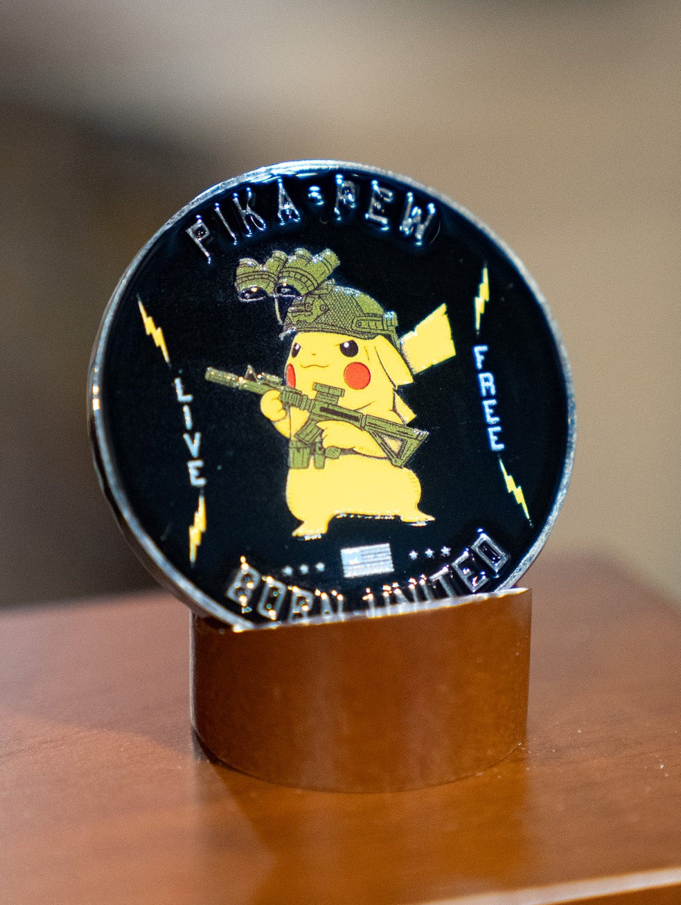 The Pika-Pew Challenge Coin by Born United Private Label features Pikachu in tactical gear with rifle and night vision goggles, “LIVE FREE” and “2021 UNITED” on the edge, bold “Pika Pew,” and yellow lightning bolts.