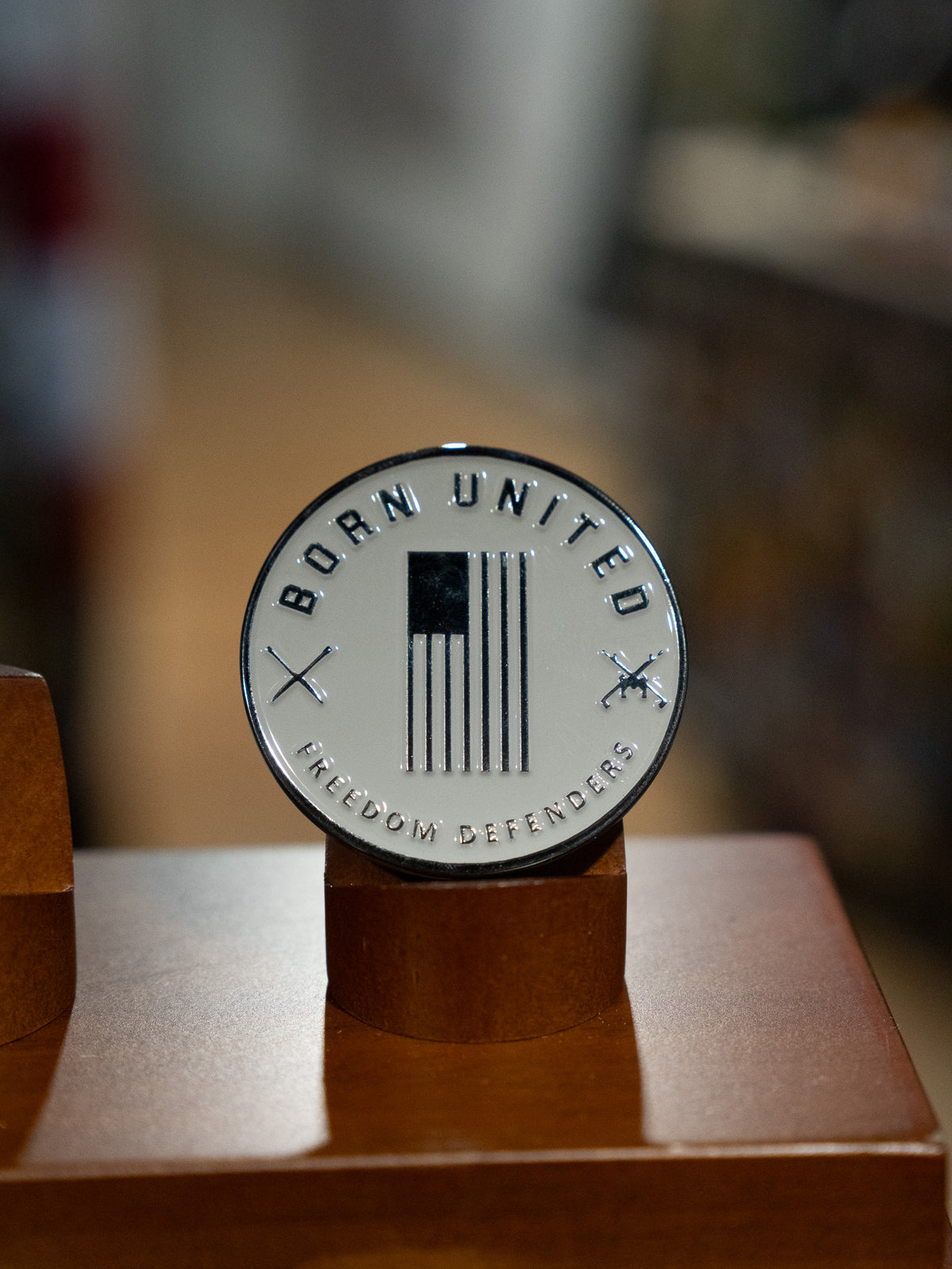 The Brick Operator Challenge Coin by Born United Private Label is a round silver medallion with "BORN UNITED" above, "FREEDOM DEFENDERS" below, a black and white US flag, crossed rifles, and Brick Operator craftsmanship details.
