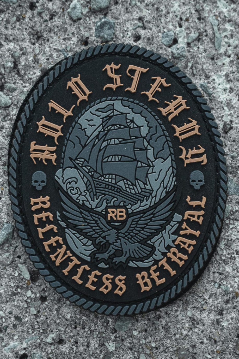 The Hold Steady Ghost Patch by Relentless Betrayal is a 3-inch Velcro patch with an embroidered sailing ship, eagle, RB initials, skull details, and the phrases HOLD STEADY and RELENTLESS BETRAYAL on textured gray.