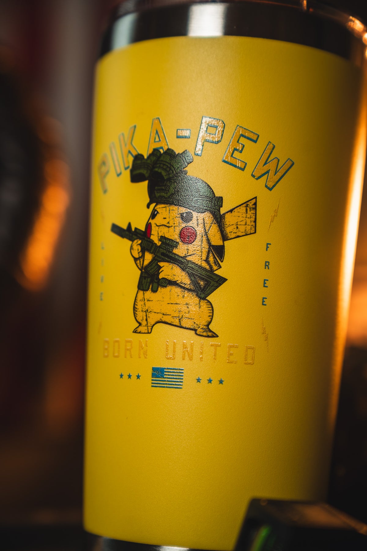 The Pika-Pew Tumbler - 20oz by Born United Private Label features a yellow design with Pikachu in military gear holding a rifle, "PIKA-PEW" text above, and "BORN UNITED" with a small American flag below.