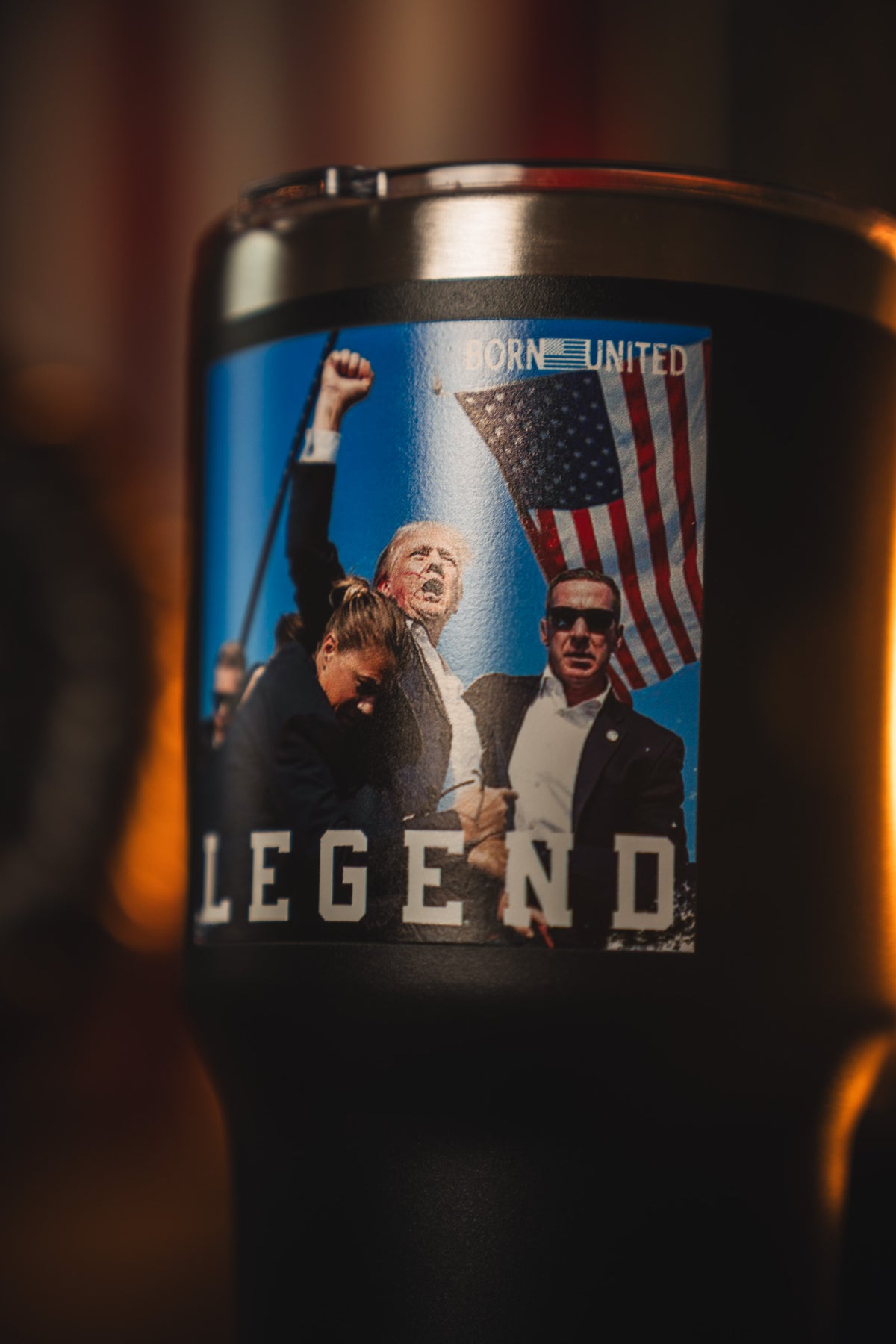 The Born United Private Label Forever Legend Tumbler - 30oz features a man in a suit raising his fist with security agents and an American flag, plus the words BORN UNITED and LEGEND on the design.