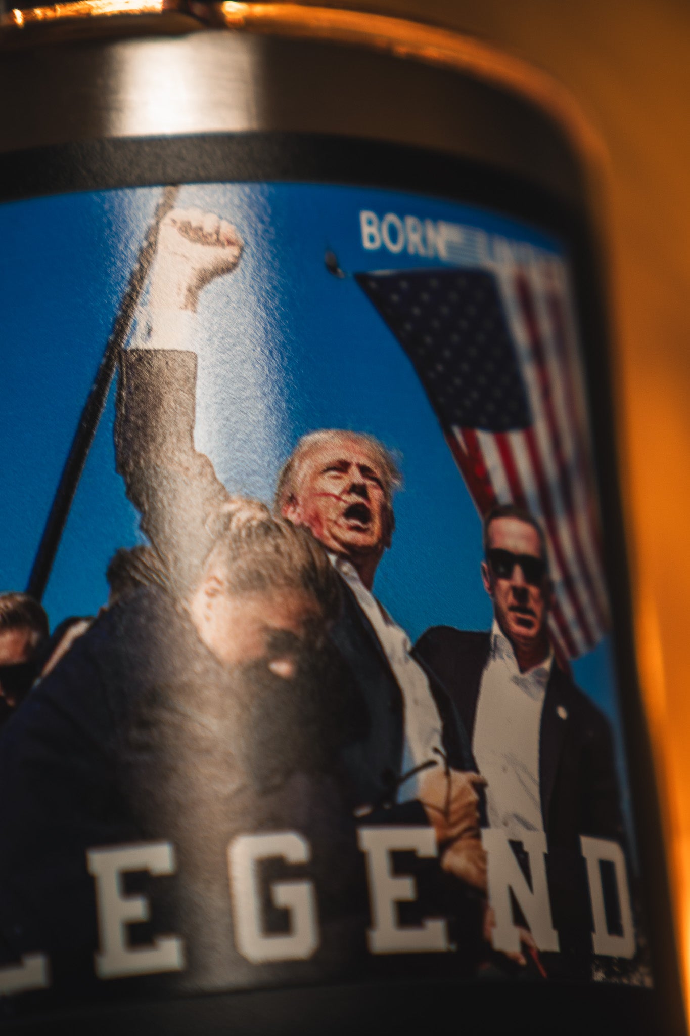 A close-up of the Born United Private Label "Forever Legend Tumbler - 30oz" featuring a man in a suit raising his fist, an American flag backdrop, and "LEGEND" partially visible at the bottom.