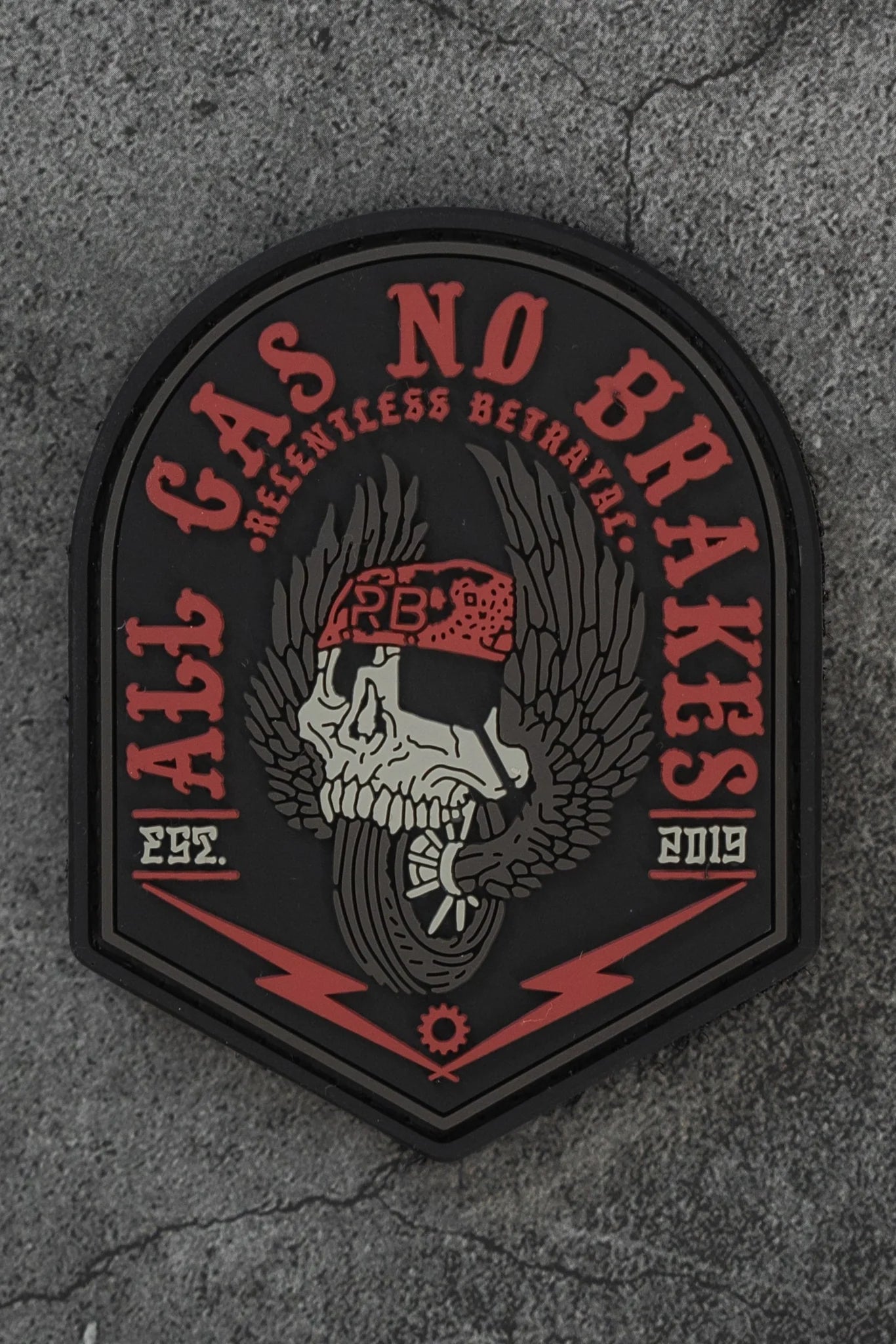 The All Gas No Brakes PVC Patch by Relentless Betrayal features a skull with a red bandana, black wings, bold red text reading "All Gas No Brakes" and "Relentless Betrayal," plus "EST. 2019" at the bottom.