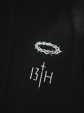 The 13th brand’s Jesus Saves Hoodie is black, with a white thorn crown above “13TH”—the “T” is shaped like a cross.