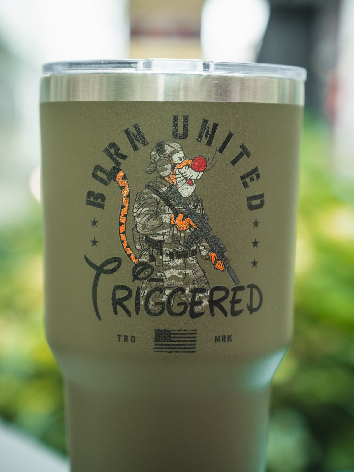 The Triggered Tumbler - 30oz by Born United Private Label is a green tumbler featuring Tigger as a soldier with a rifle, “Born United Triggered” text, and the American flag below.