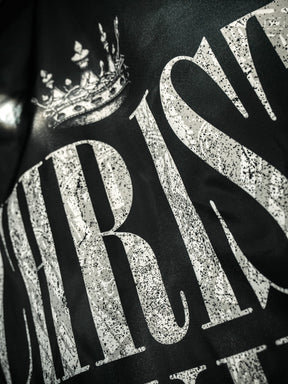 Close-up of "CHRIST" in large, white, glittery letters with a crown above on a dark background. A striking design by 13th, perfect for displaying your faith with the Christ is King Flag.
