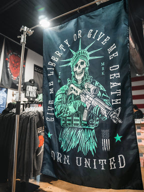 The Liberty or Death Flag by Born United Private Label features a skeletal Lady Liberty with a rifle and the words “Give Me Liberty Or Give Me Death” and “Born United”—a bold piece inspired by revolutionary spirit.