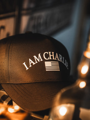 The I Am Charlie Black Snapback by Born United Private Label features "I AM CHARLIE" and an American flag on the front—a stylish choice for fans of handmade hats.