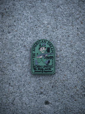 The American Dream PVC Patch by Born United Private Label features a cartoon soldier with a gun and cash, labeled "THE AMERICAN DREAM," with the text below: "Born United, Proudly served, pursued by happiness.