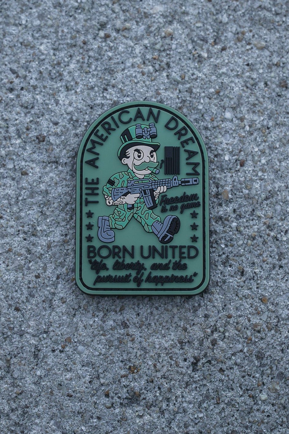 A cartoon soldier with a rifle is featured on the American Dream PVC Patch by Born United Private Label, with text: THE AMERICAN DREAM, BORN UNITED, For liberty and the pursuit of happiness, and Freedom is not free.