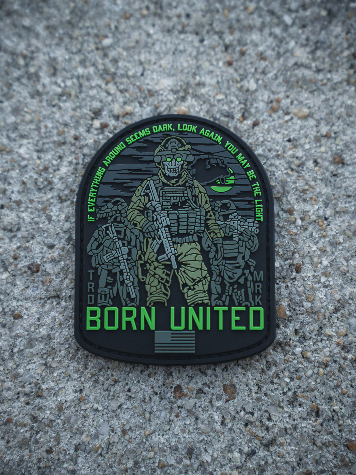The Light in the Darkness PVC Patch by Born United Private Label features four armed soldiers with night vision gear on gravel, the quote "If everything around seems dark, look again, you may be the light," and "Born United" below.