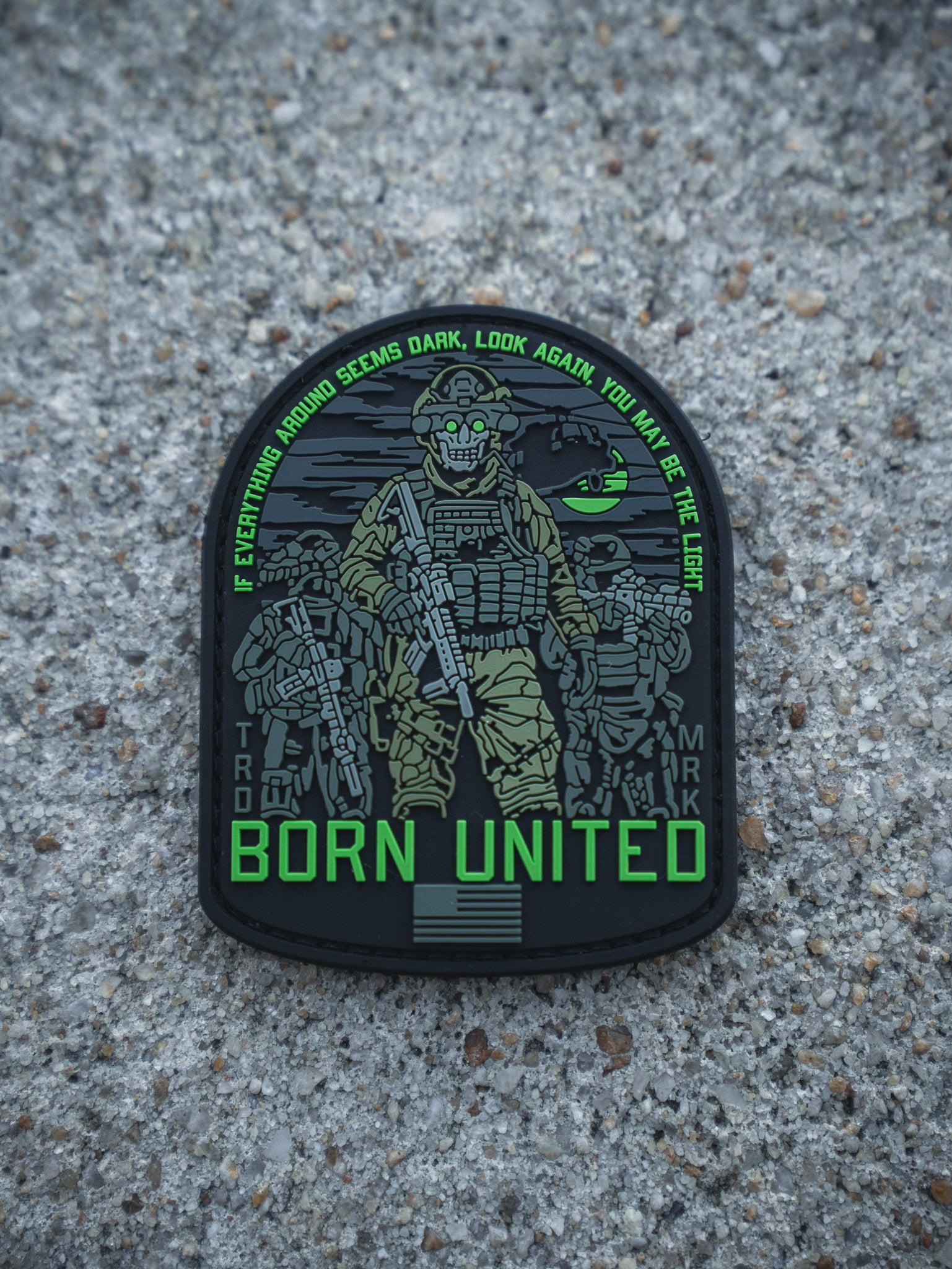 The Light in the Darkness PVC Patch by Born United Private Label features four armed soldiers with night vision gear on gravel, the quote "If everything around seems dark, look again, you may be the light," and "Born United" below.